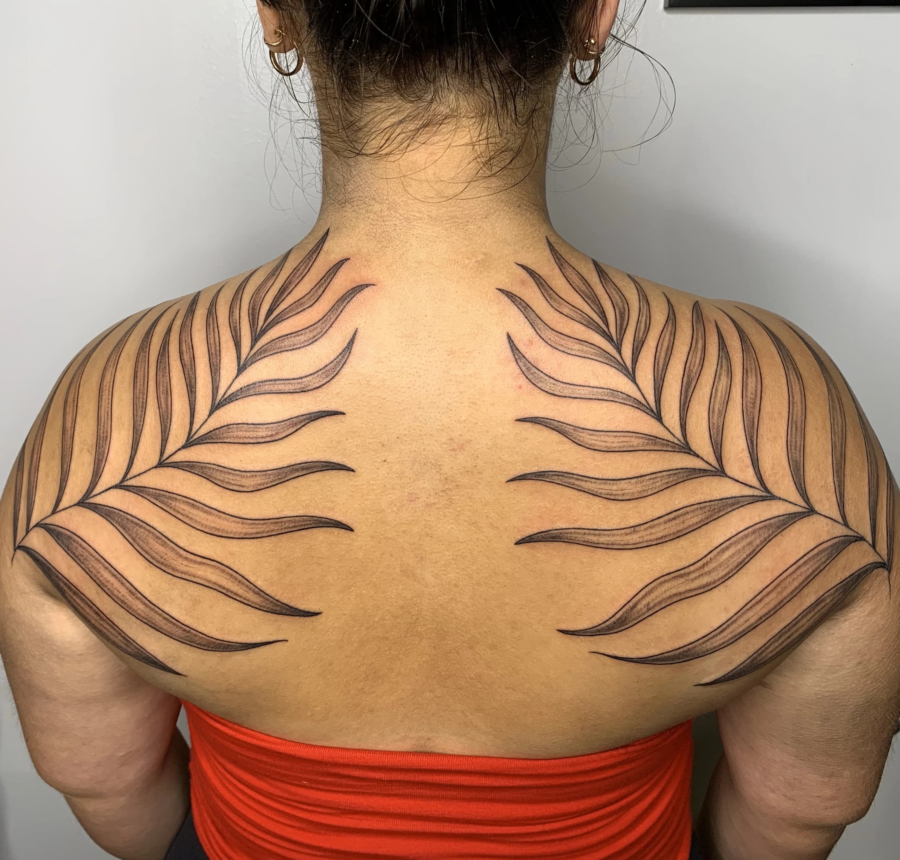 Botanical floral tattoo with flowing petals and fine stem linework